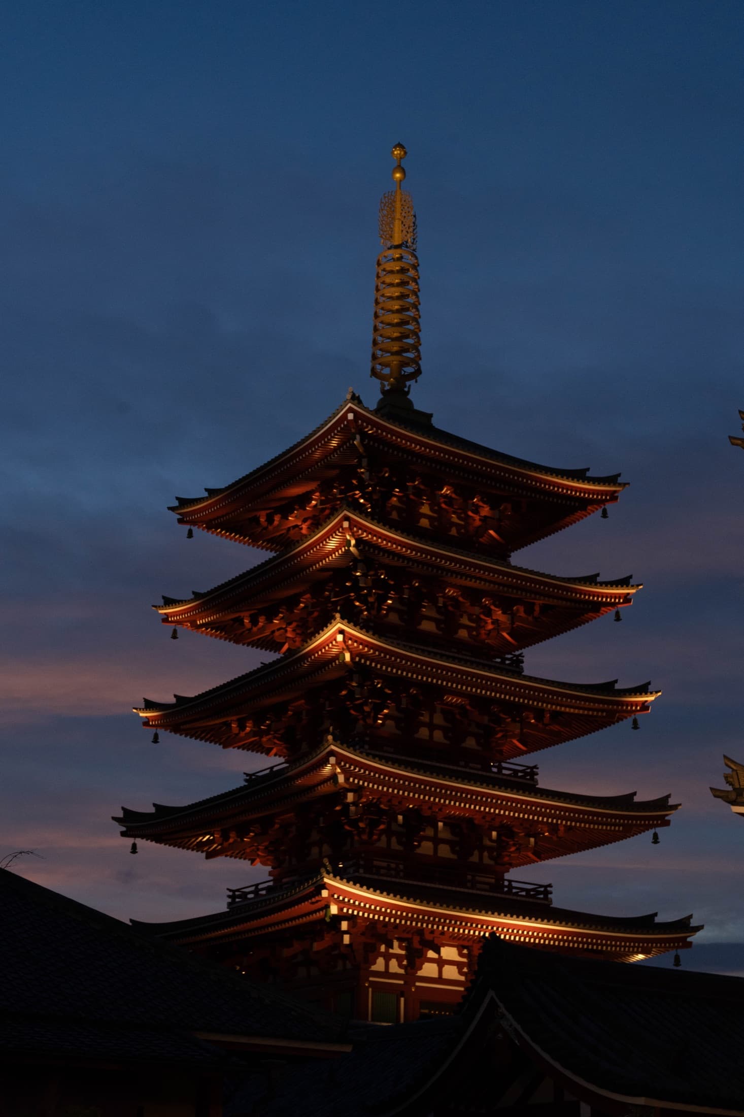 Five-storied pagoda at Sensō-ji glowing against the deep blue dusk.