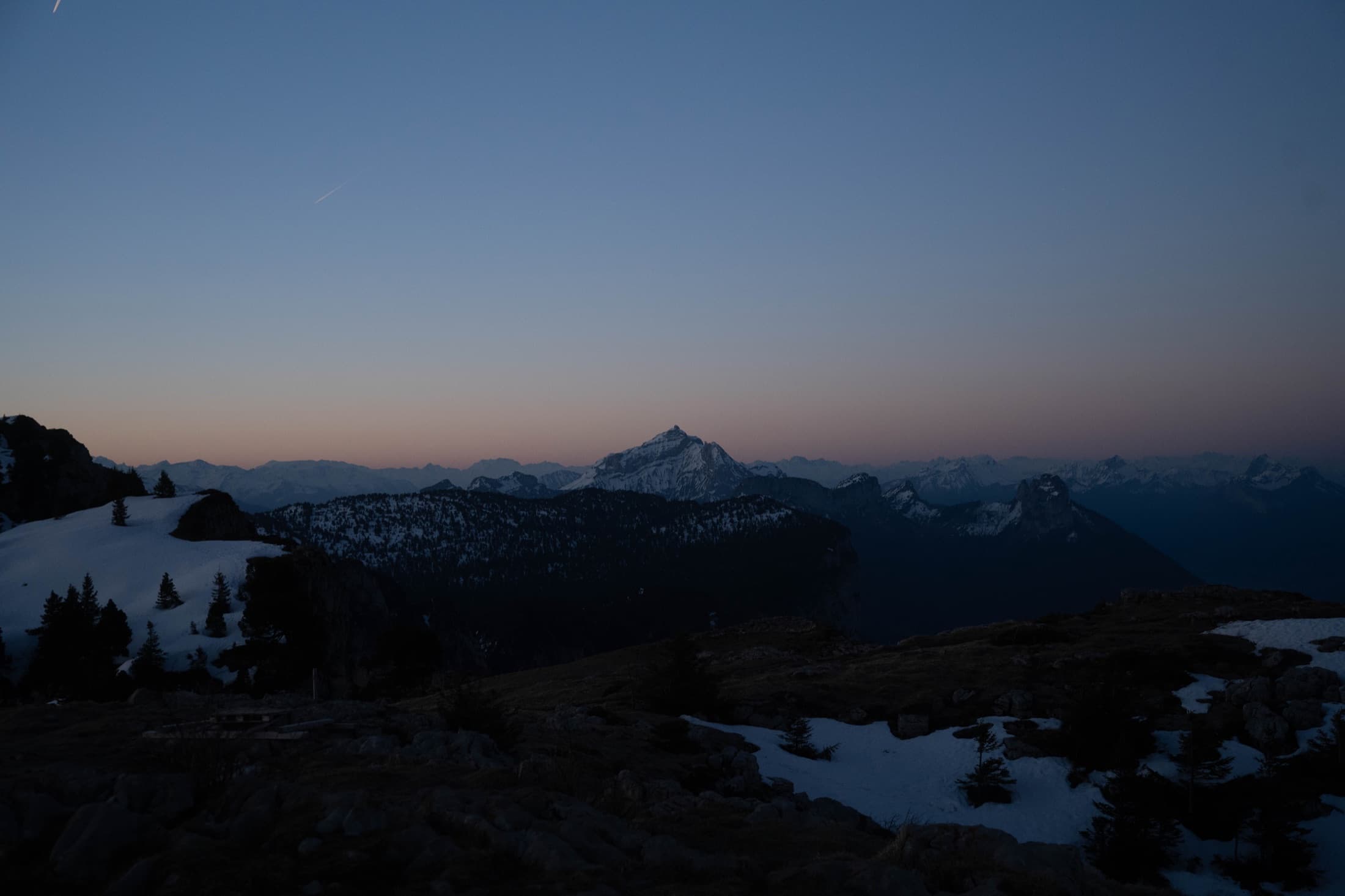 A lone peak silhouetted at twilight in the French Alps.